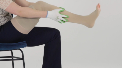 Woman rubs the wrinkles out of the compression stocking with the STEVE grip gloves.