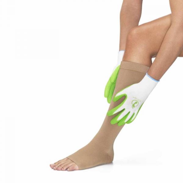 white gloves with green latex grip on the palm to aid in putting on compression stockings include one leg with a compression stocking